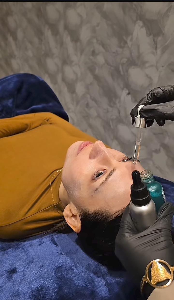 Serum dropper being applied to the skin during a facial treatment